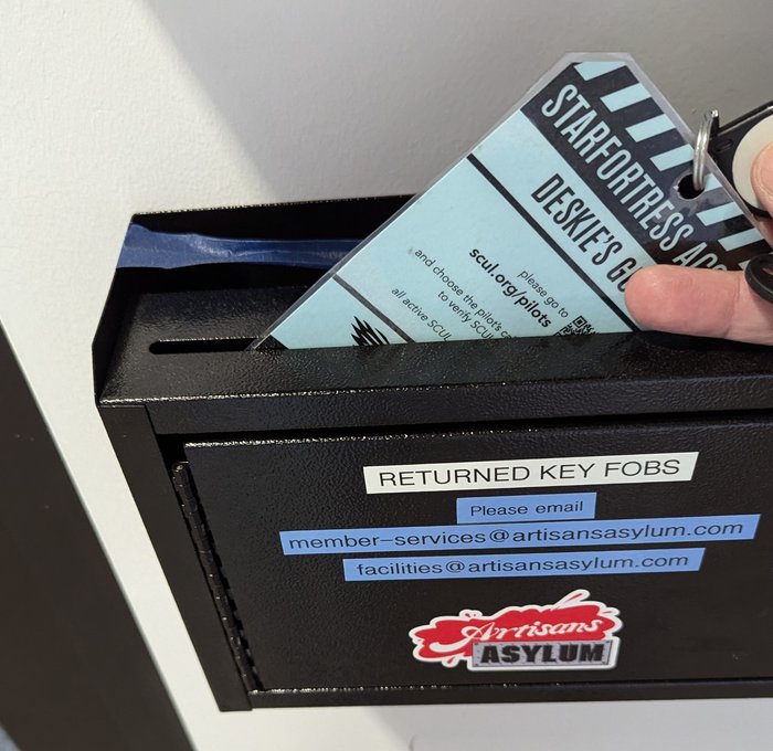 a key fob being dropped into a drop box